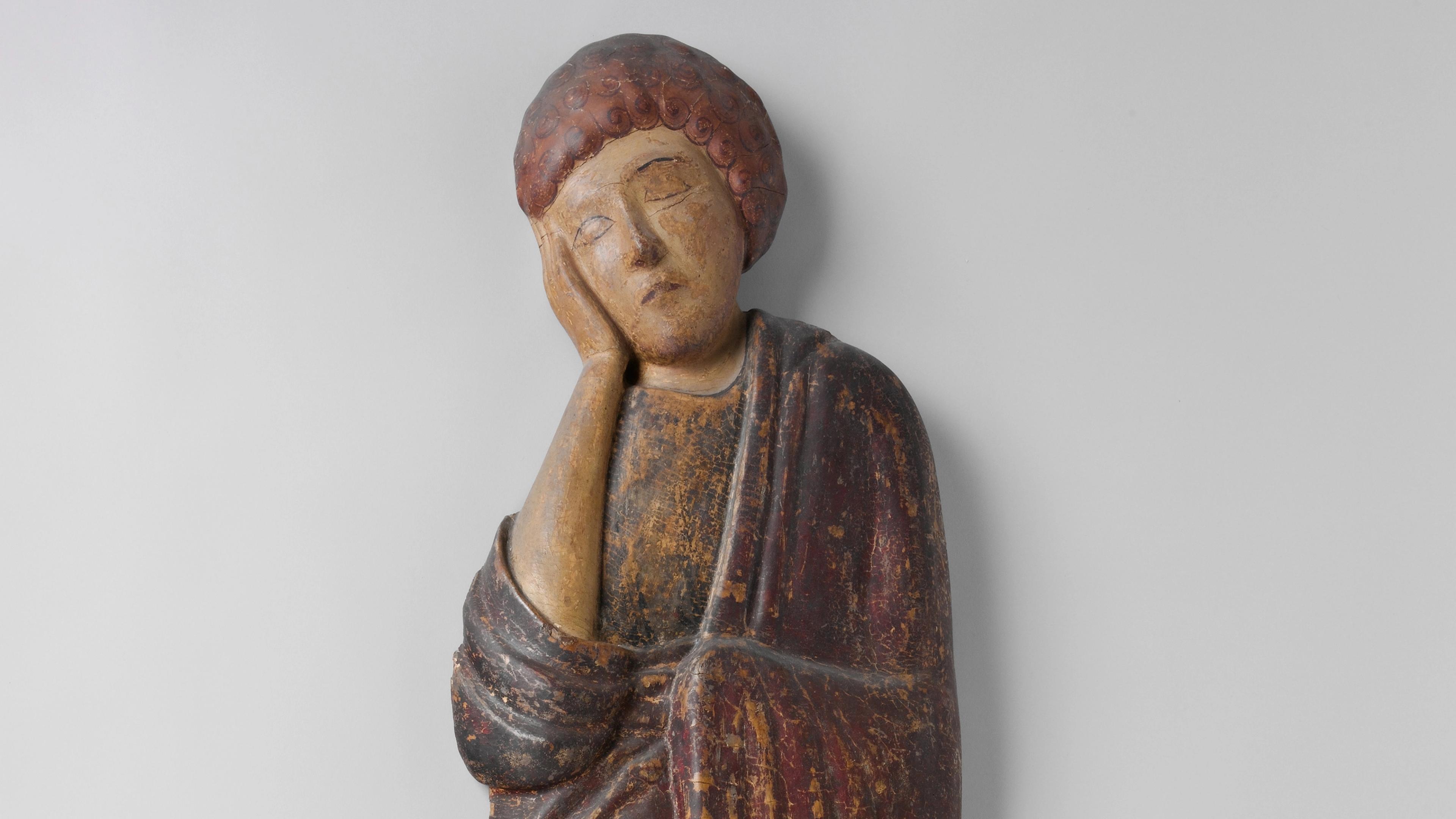 Wooden sculpture of St. John resting his face in his right hand