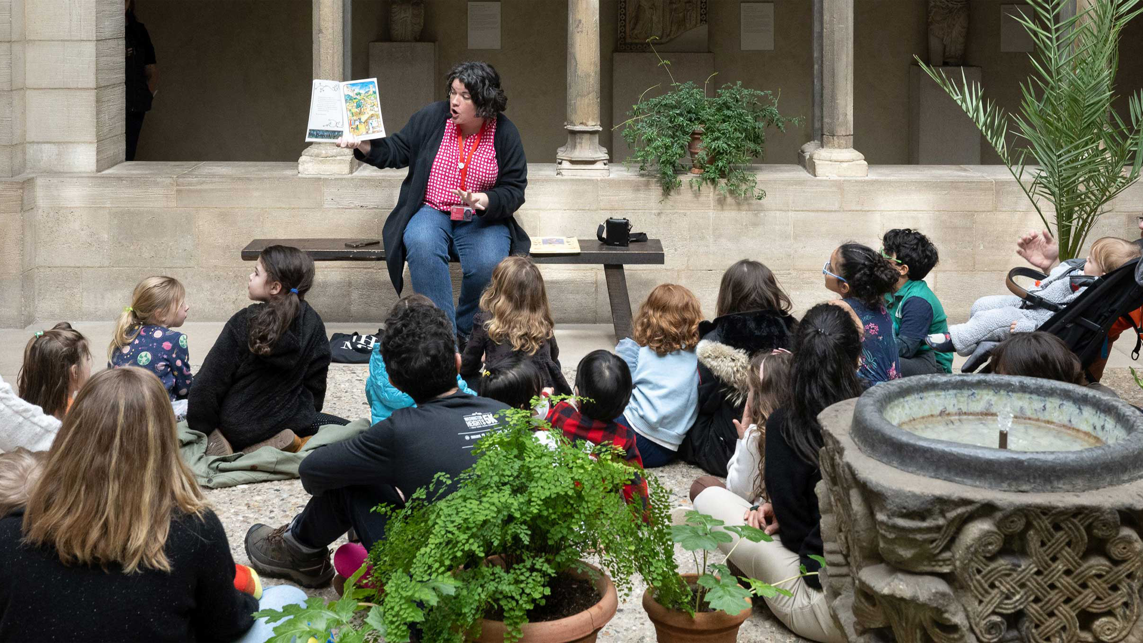 An educator reads to a room full of children in The Met Cloisters.