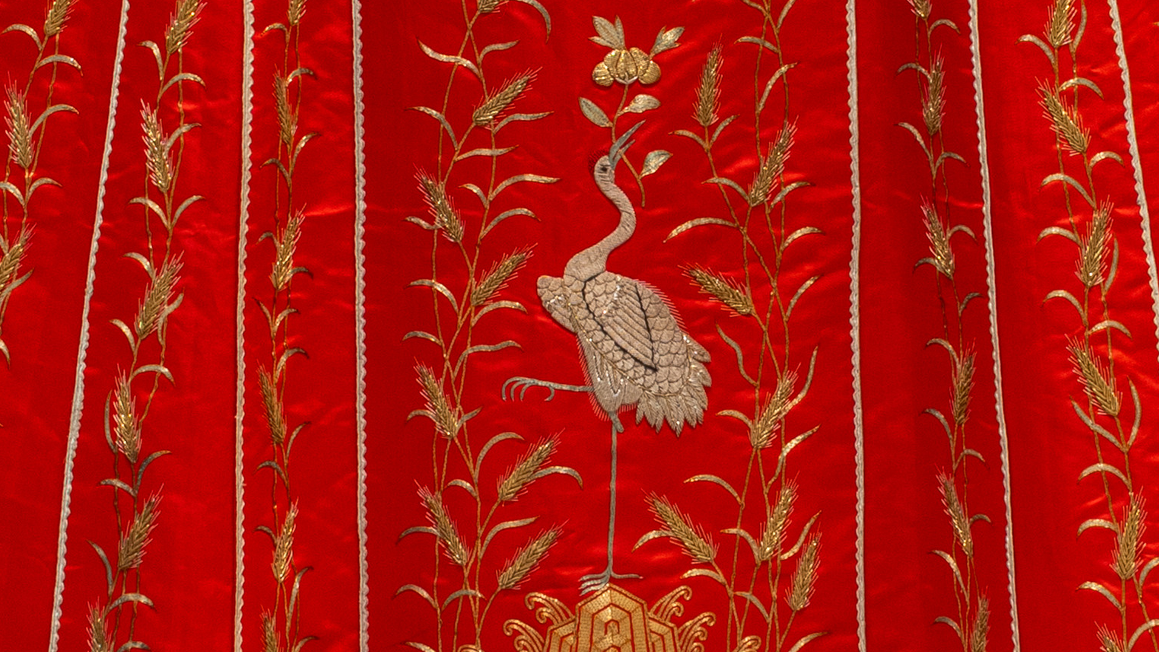 A traditional black robe features intricate gold embroidery with circular dragon motifs. 