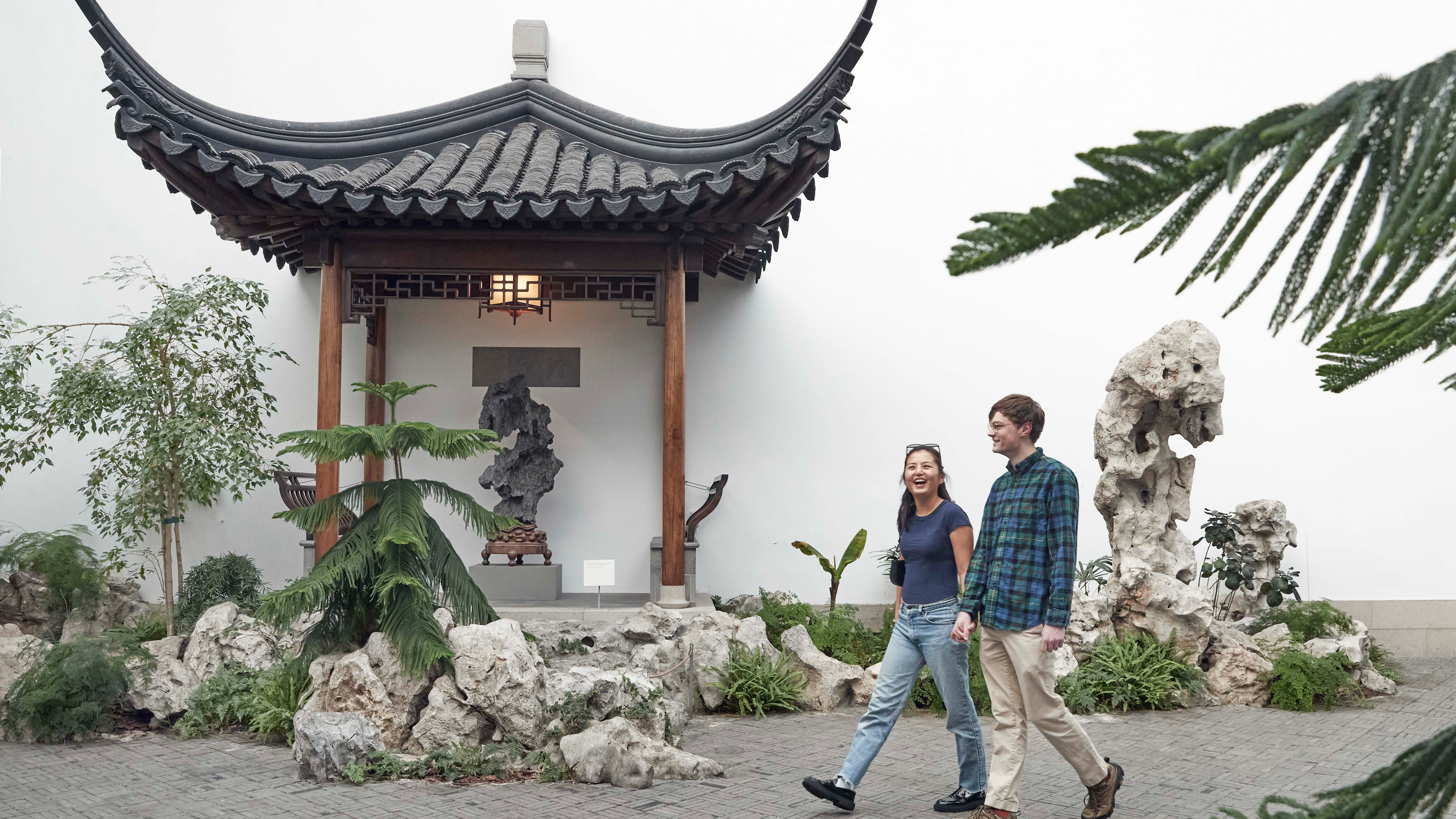Two people walking through The Astor Chinese Garden Court at The Met.